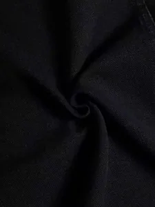 Macro view of high-quality black denim fabric showing detailed texture and weave for jacket