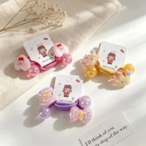 Close-up of three cute pastel hair ties with beads and character motifs on display cards
