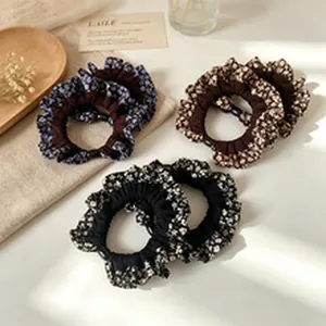 Detailed view of vintage floral patterned hair scrunchies in multiple colors on linen