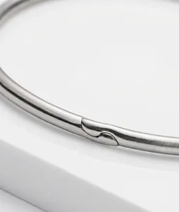 Close-up detail of a silver metal binder ring showing its secure interlocking clasp mechanism