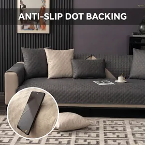 Close-up of the anti-slip dot backing on a waterproof gray sofa protector cover.