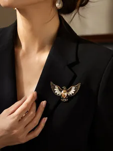 Detail view of a vintage bronze eagle brooch with amber stone pinned on a black suit.