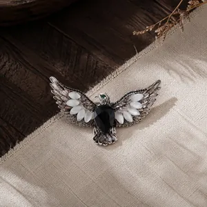 Vintage eagle brooch with wings spread, featuring black and white gemstones