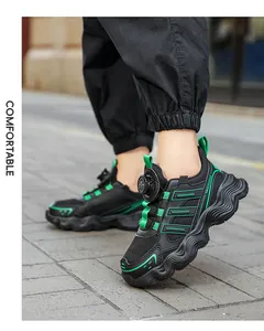 Detail of breathable mesh kids running shoes with rotating buckle closure in black.
