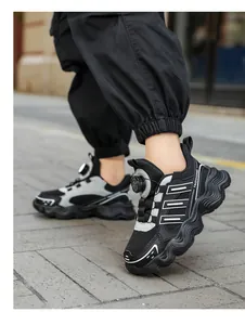 Close-up detail of breathable mesh kids' sports shoes with rotary buckle worn outdoors