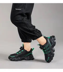 Detailed side view of kids' black running shoes with green accents and rotating buckle