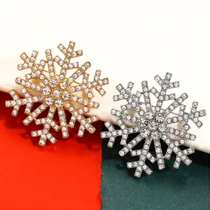 Detail view of gold and silver snowflake brooches with sparkling white rhinestones