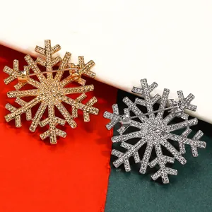 Detailed view showing the pin backing of gold and silver snowflake Christmas brooches