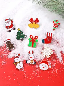 Collection détaillée de divers pins de Noël en émail sur un fond de neige.