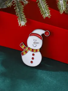Détail d'une broche bonhomme de neige en émail festif avec bonnet et écharpe rouge