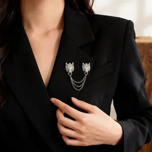 Detail of vintage silver dragon brooch with triple chains pinned to a black suit lapel