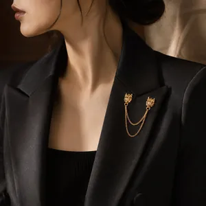 Detail view of a vintage gold dragon head chain brooch pinned on a black suit lapel