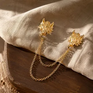 Detailed close-up of vintage golden dragon head brooch with double chain for men's suit