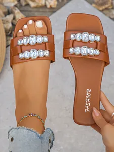 Vue détaillée de sandales plates marron chic avec boucles luxueuses en cristal