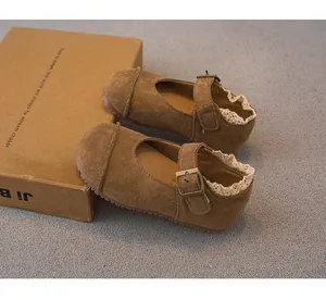 Close-up of brown suede girls' Mary Jane shoes with lace trim and buckle detail