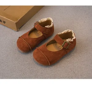 Close-up of brown suede girls' princess shoes with lace trim and buckle detail