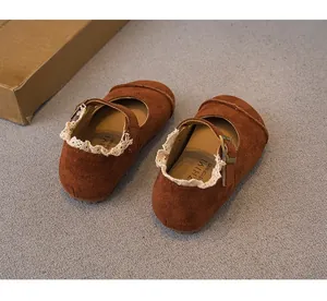 Detailed view of brown suede girls' Mary Jane shoes with lace trim and buckle strap