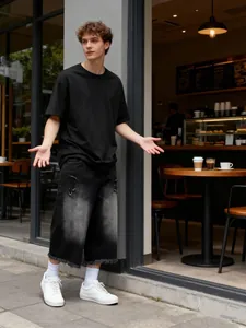 Dettaglio di pantaloncini di jeans da uomo sfumati in un ambiente caffè elegante.