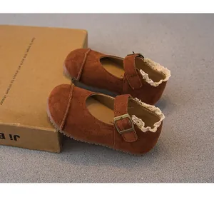 Close-up detail of brown suede girls' Mary Jane shoes featuring elegant white lace trim