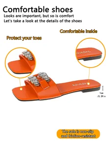 Détail de sandale plate orange avec boucle en cristal et talon de 1 cm de haut