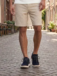 Close-up of men's summer casual waffle shorts with square grid texture on street.