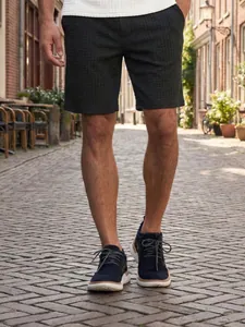 Men's black waffle-knit casual summer shorts shown in a stylish outdoor street setting