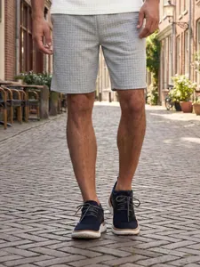 Detailed view of grey waffle textured men's shorts in a summer street setting
