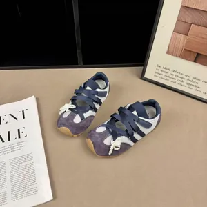 Primo piano di scarpe balletto bambina in camoscio viola e dettaglio perle