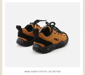 Detailed view of kids' soft-sole sneakers in mustard yellow suede with black accents
