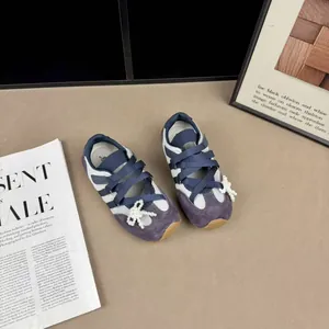 Dettaglio di scarpe da ginnastica viola per bambina con eleganti fiocchi di perle