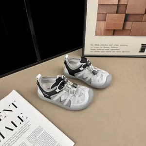 Detail view of children's grey mesh breathable sneakers with toggle laces and black accents