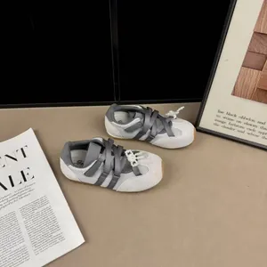Dettaglio delle sneakers stile balletto in mesh grigio con perle e nastri per bimba.