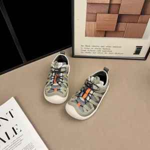 Breathable mesh sneakers for kids with adjustable bungee laces and orange accents.