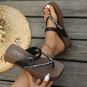 Detail showing thick sole women's flip-flops with snake print and buckle accents.