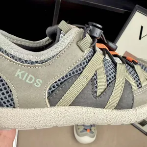 Macro detail of breathable mesh upper and toggle lacing system on kids' running sneakers