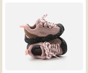 Close-up of pink and brown children's soft sole sneakers with speckled black outsoles