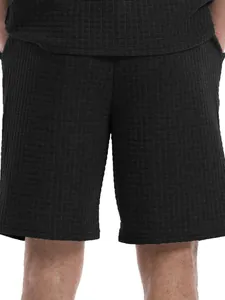 Close-up view of men's black waffle knit sports shorts showing fabric texture and detail