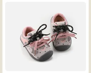 Detailed view of pink and grey polka dot baby walking shoes with double laces and non-slip sole