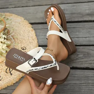 Detail shot of brown and white platform thong sandals with buckle ornament