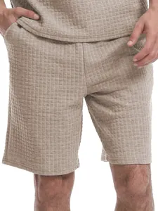 Close-up detail view of men's beige shorts set with a textured waffle grid pattern