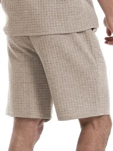 Detailed view of men's beige waffle knit leisure shorts set showing fabric texture