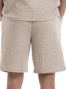 Close-up detail of men's casual waffle knit shorts featuring a small grid texture in beige