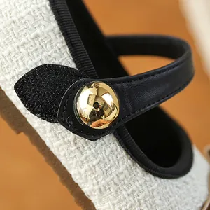 Vue détaillée en gros plan du tissu en tweed blanc et du bouton doré sur chaussure fille