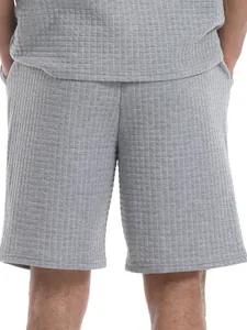 Detailed view of men's gray grid pattern casual sports shorts with loose fit texture