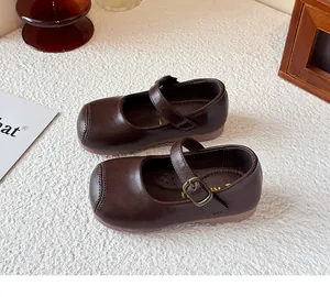 Close-up of girl's brown British style Mary Jane shoes with a vintage buckle and soft sole