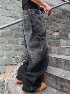 Détail du jean dégradé gris vintage à jambes larges avec une chaîne métallique