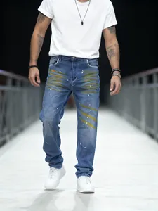 Dettaglio dei jeans dritti blu da uomo con artistici schizzi di vernice gialla