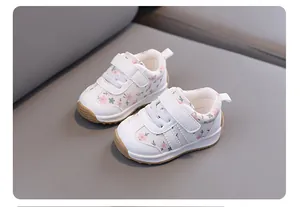 Detail view of toddler floral sneakers with white leather finish and soft rubber soles.