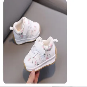 Detailed close-up of white baby walking shoes with pink floral print and soft sole