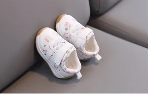 Pastoral floral baby walking shoes with white leather and soft rubber soles.